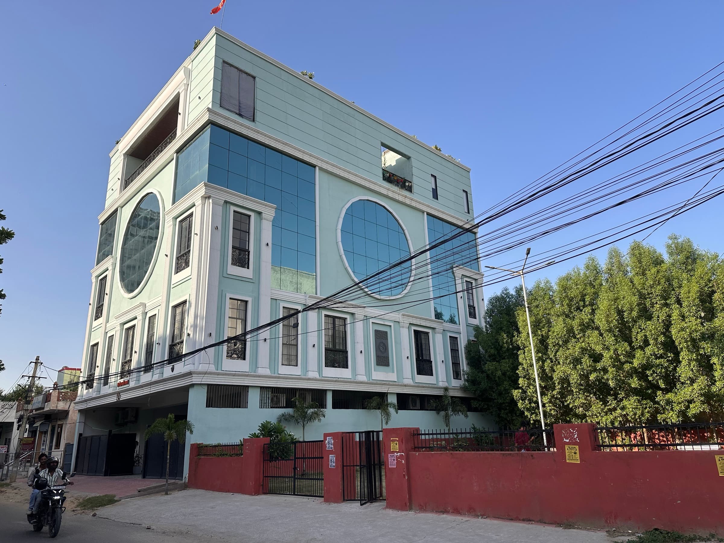 The JaipurCowork building on Haldighati Marg in daylight: a mint-green facade with two large round windows