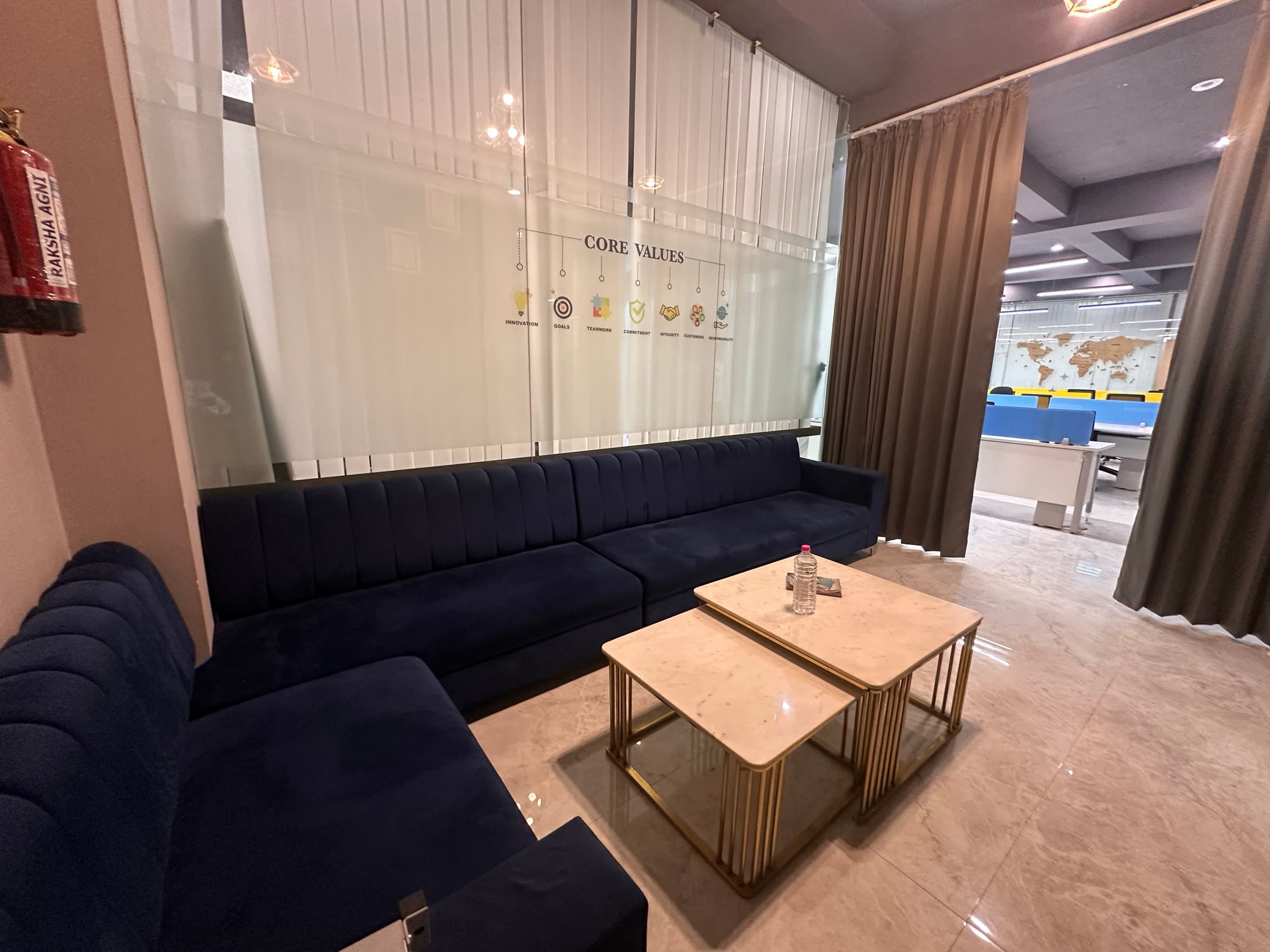 Lounge with a navy velvet sofa and marble-top nesting tables with brass legs