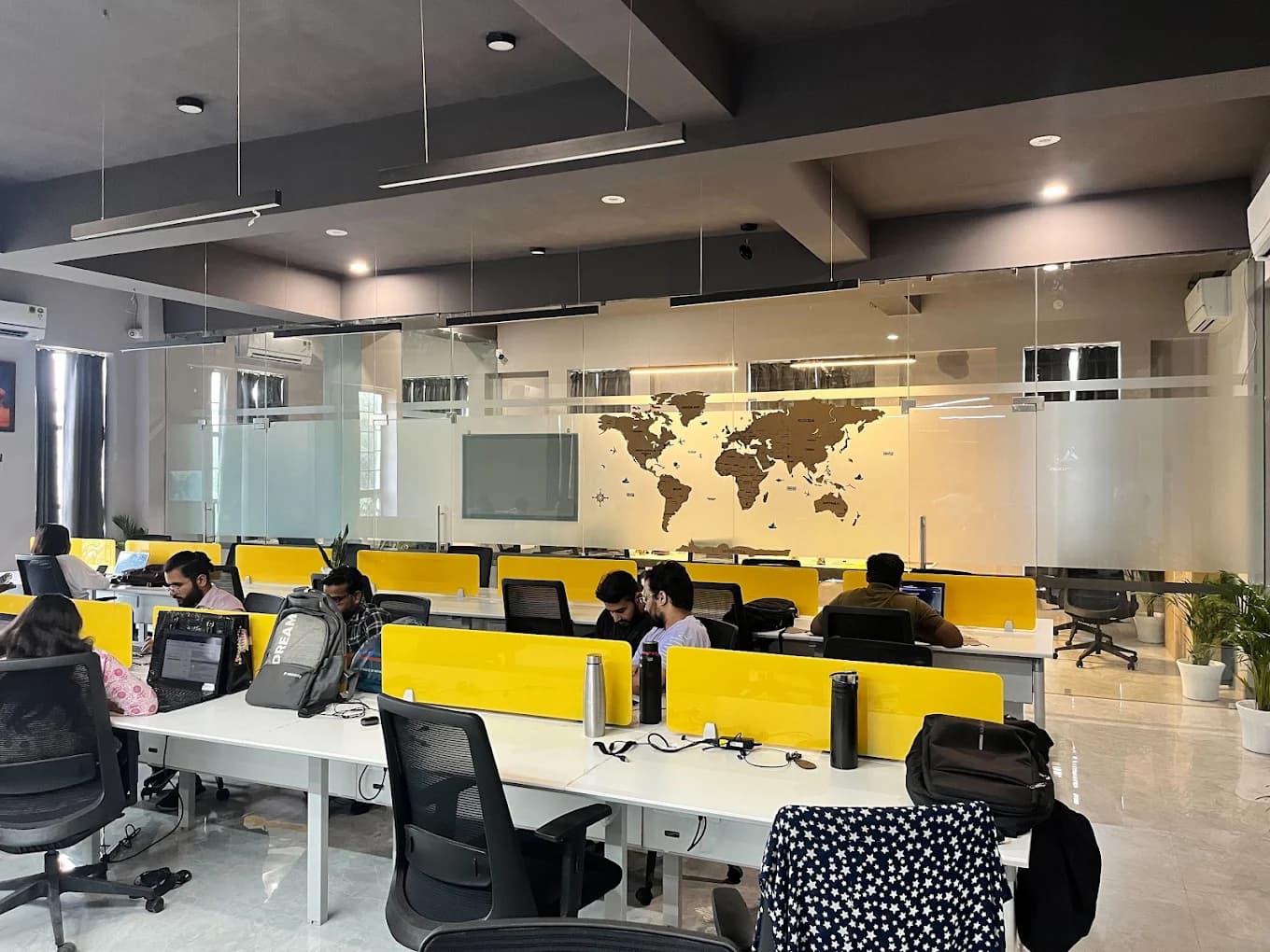 Members working on laptops at shared desks on the JaipurCowork floor